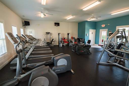 A gym with treadmills, elliptical machines, and other exercise equipment.