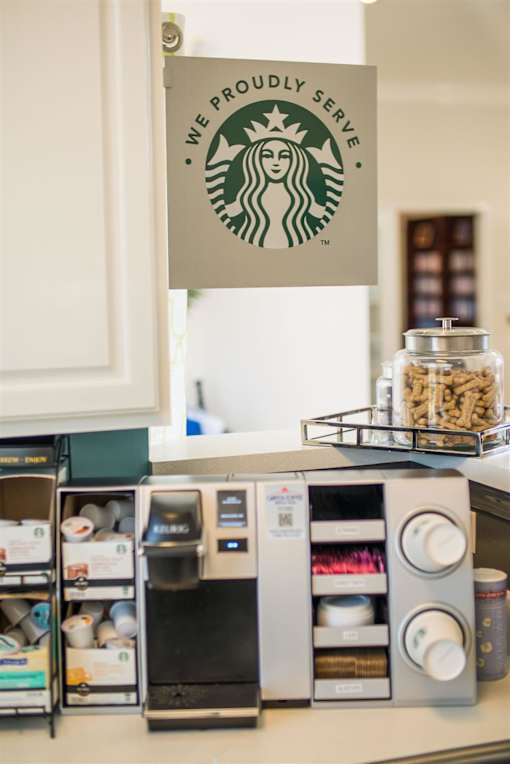 A Starbucks sign hangs over a coffee machine.