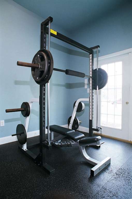 A black weight bench with a barbell on top of it.