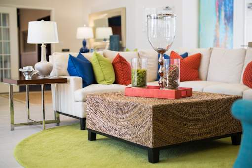 A living room with a white couch and a brown woven coffee table.