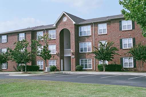 A red brick apartment building with a large arched entrance.