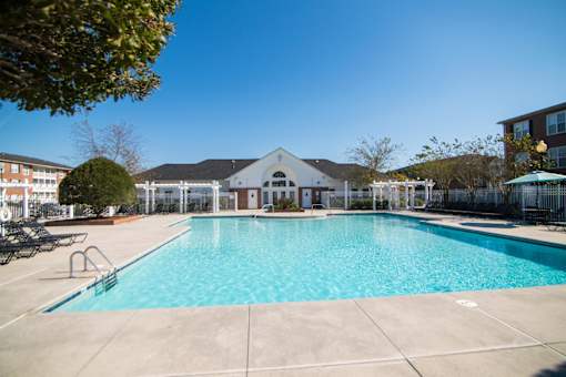 A large swimming pool with a building in the background.