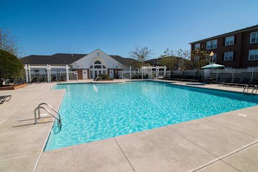 A large swimming pool in a sunny outdoor setting.