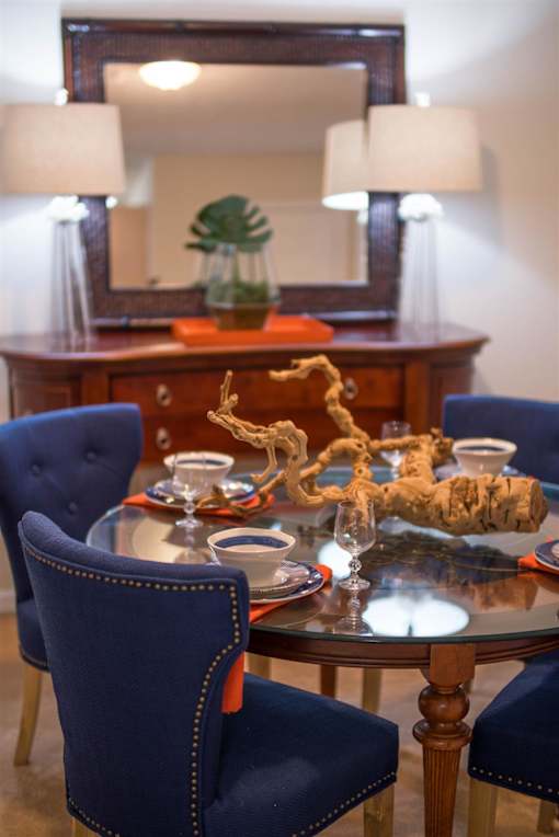 A dining room with a round table and blue chairs.