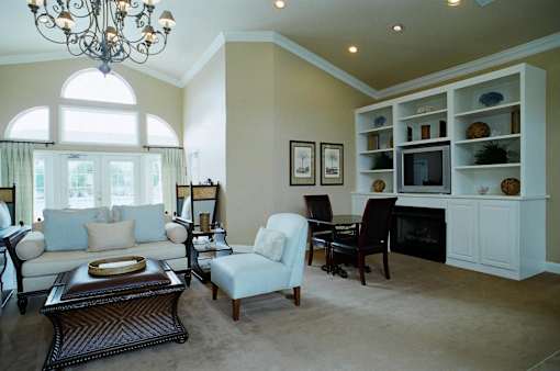 A living room with a white couch, a coffee table, and a chandelier.