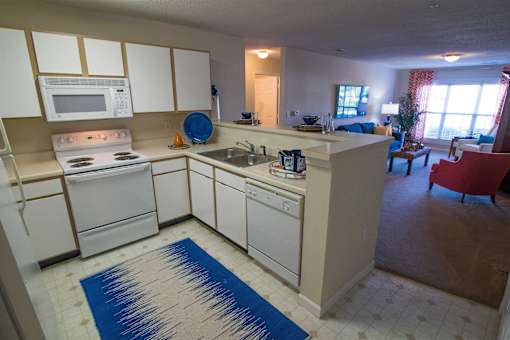A kitchen with white appliances and cabinets.