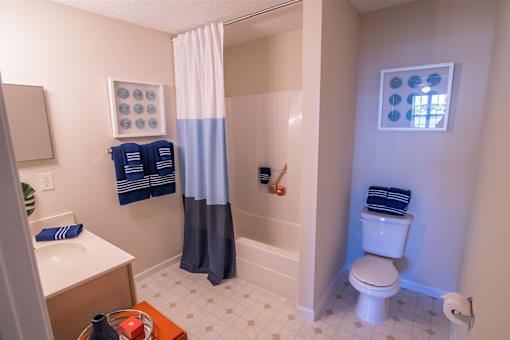 A bathroom with a toilet, sink, and shower.