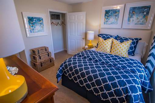 A bedroom with a bed covered in a blue and white patterned comforter.