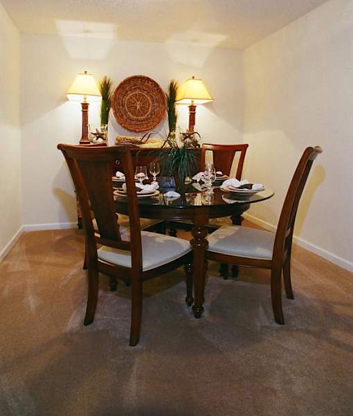 A dining table with chairs and a woven basket on it.