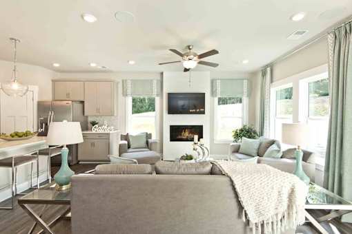 A modern living room with a grey couch and a fireplace.