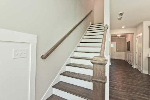 A staircase with wooden steps and a dark brown handrail.