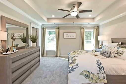A bedroom with a bed, dresser, and mirror.