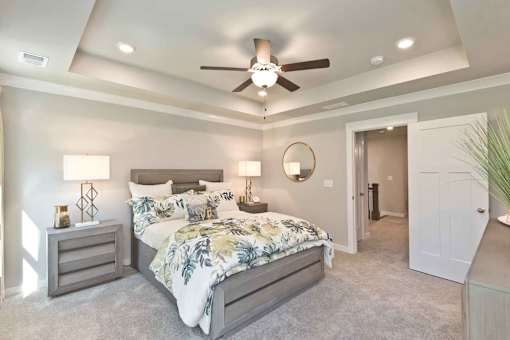 A bedroom with a large bed and a ceiling fan.