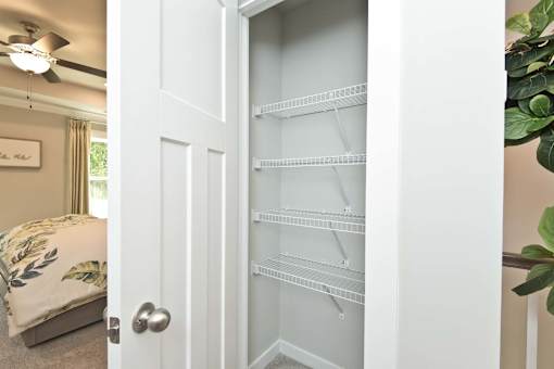 A white door with a shelf is open.