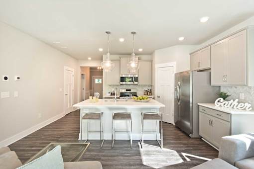 A modern kitchen with a dining area and a living room.