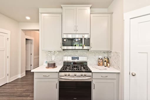 A kitchen with a stove top oven and a range hood above it.