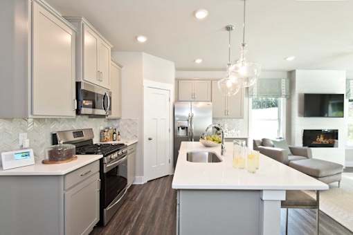 A modern kitchen with a large island and a fireplace in the living room.