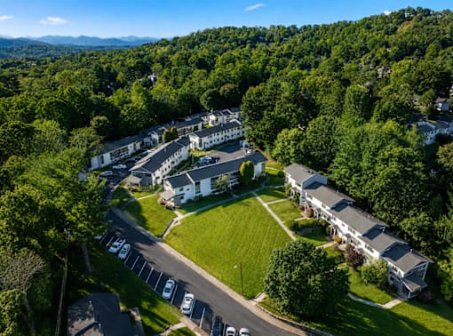 A bird's eye view of a residential area with houses and parked cars.