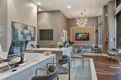 A reception area with a desk, chairs, and a painting on the wall.