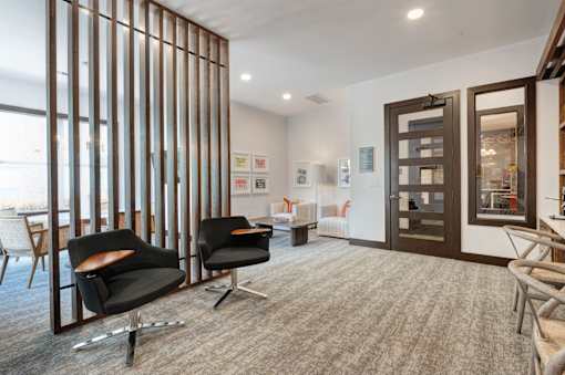 A room with a grey carpet and a brown door.
