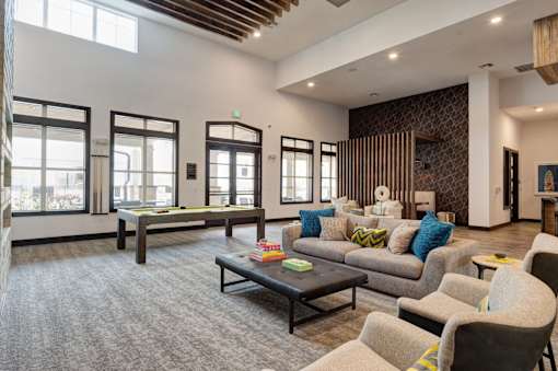 A living room with a grey carpet and a wooden ceiling.