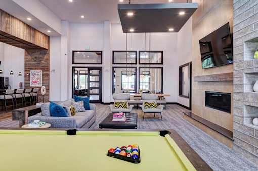 A pool table with a yellow cloth and a set of balls on it.