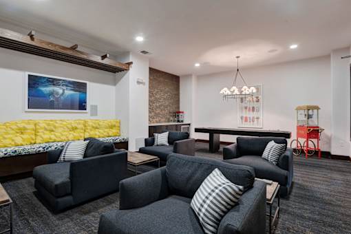 A modern living room with grey couches and a yellow sofa.