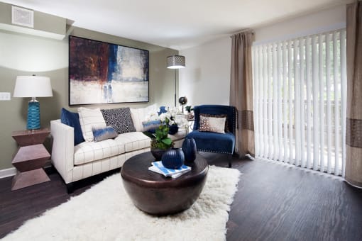Ardenne Apartments model apartments with a white couch, blue chair and hardwood-style floor