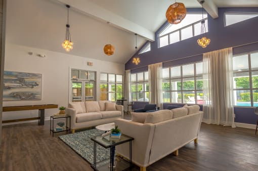 a living room with couches and a table and windows