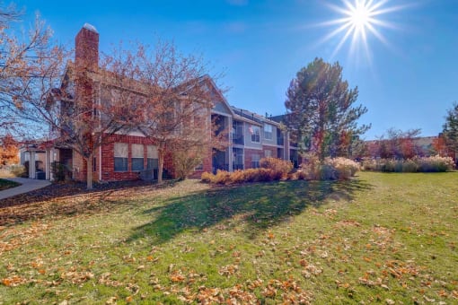 a large brick house with the sun shining in front of it