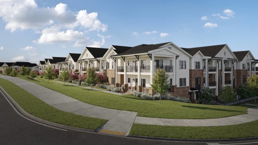 a row of townhouses on a street with grass