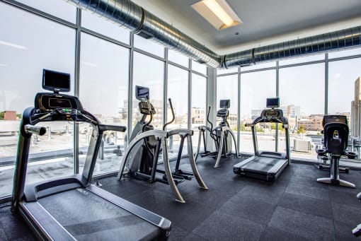 a gym with floor to ceiling windows and cardio equipment