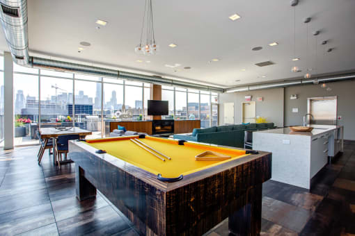 a pool table in a party room with a view of the city