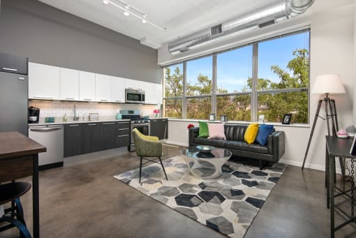 a living room with a kitchen and a large window