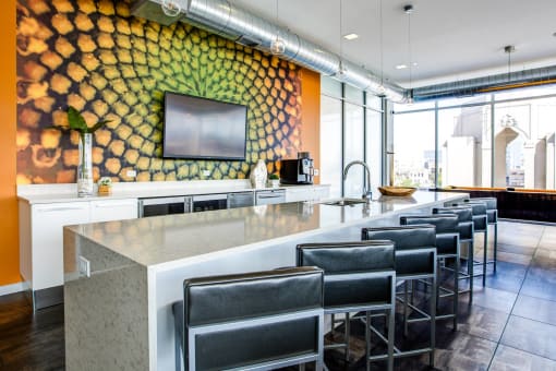 a bar with chairs in front of a counter and a yellow wall
