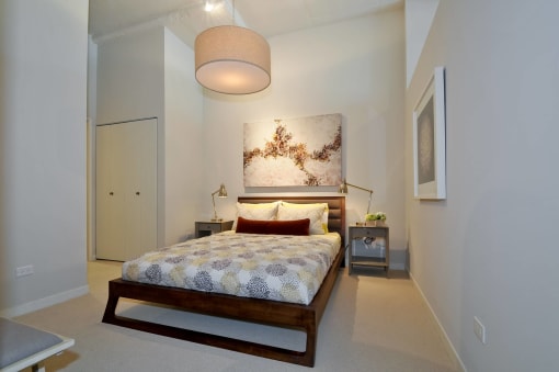a bedroom with a bed and a painting on the wall