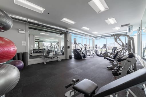 a gym with cardio equipment and windows in a building