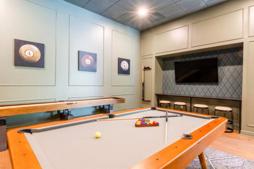 a game room with a pool table and a tv