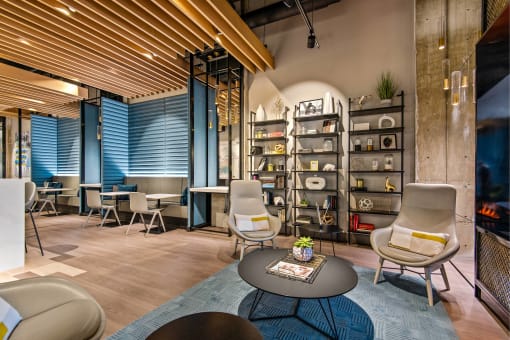 a lobby with chairs and tables and a bookshelf