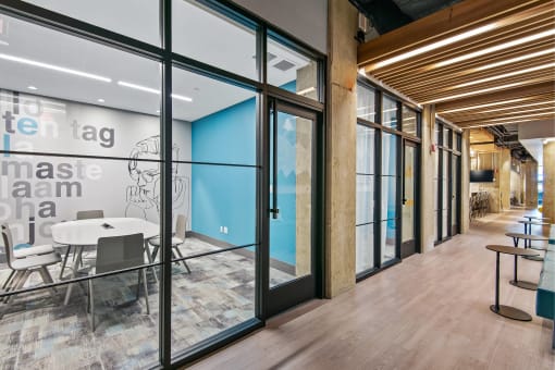 a conference room with glass doors and a table and chairs