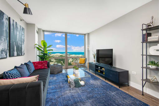 a living room with a couch and a tv and a view of the ocean