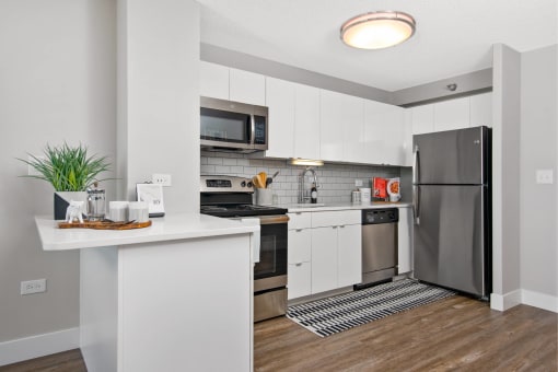 a white kitchen with stainless steel appliances and a counter top