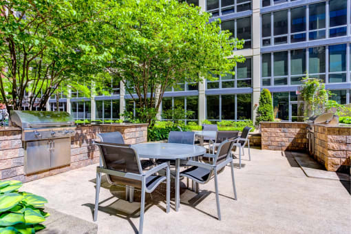 a patio with a table and chairs in front of a building
