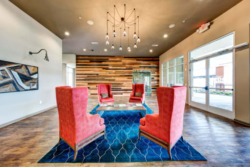 a lounge area with chairs and a table and a chandelier