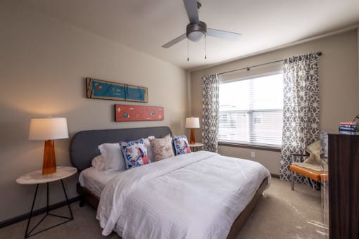 a bedroom with a bed and a ceiling fan