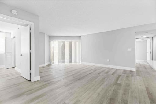 an empty living room with white walls and wood floors
