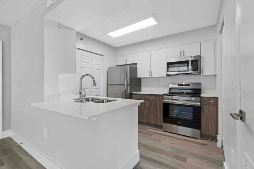 a kitchen with a white counter top and a sink