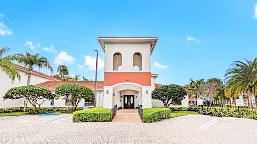 a mansion with a red and white facade and palm trees