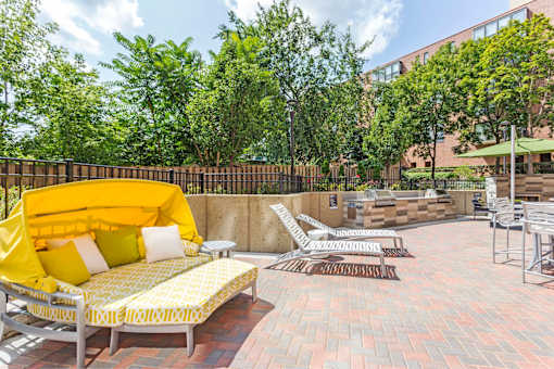 A yellow couch with a yellow cushion is on a patio.