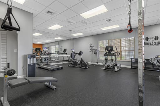 a gym with cardio equipment and weights on the floor